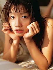 Beautiful gravure idol chick laying around in bed in white shorts